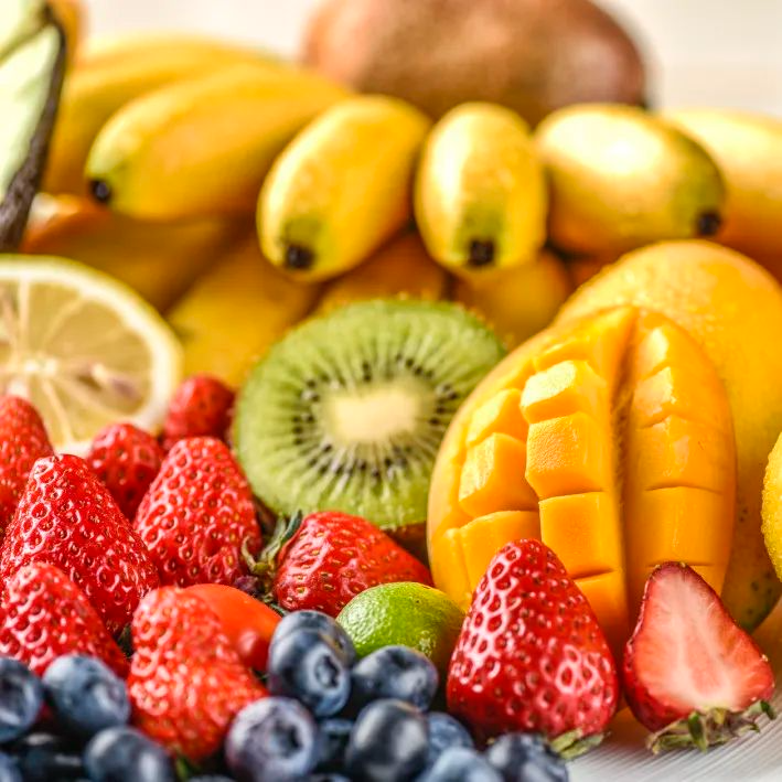 这张图片展示了一组新鲜的水果，包括草莓、蓝莓、猕猴桃、芒果、香蕉和柠檬。这些水果色彩鲜艳，排列整齐，给人一种健康和美味的感觉。